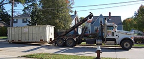 Delivery Truck Dropping Off a Roll Off Dumpster